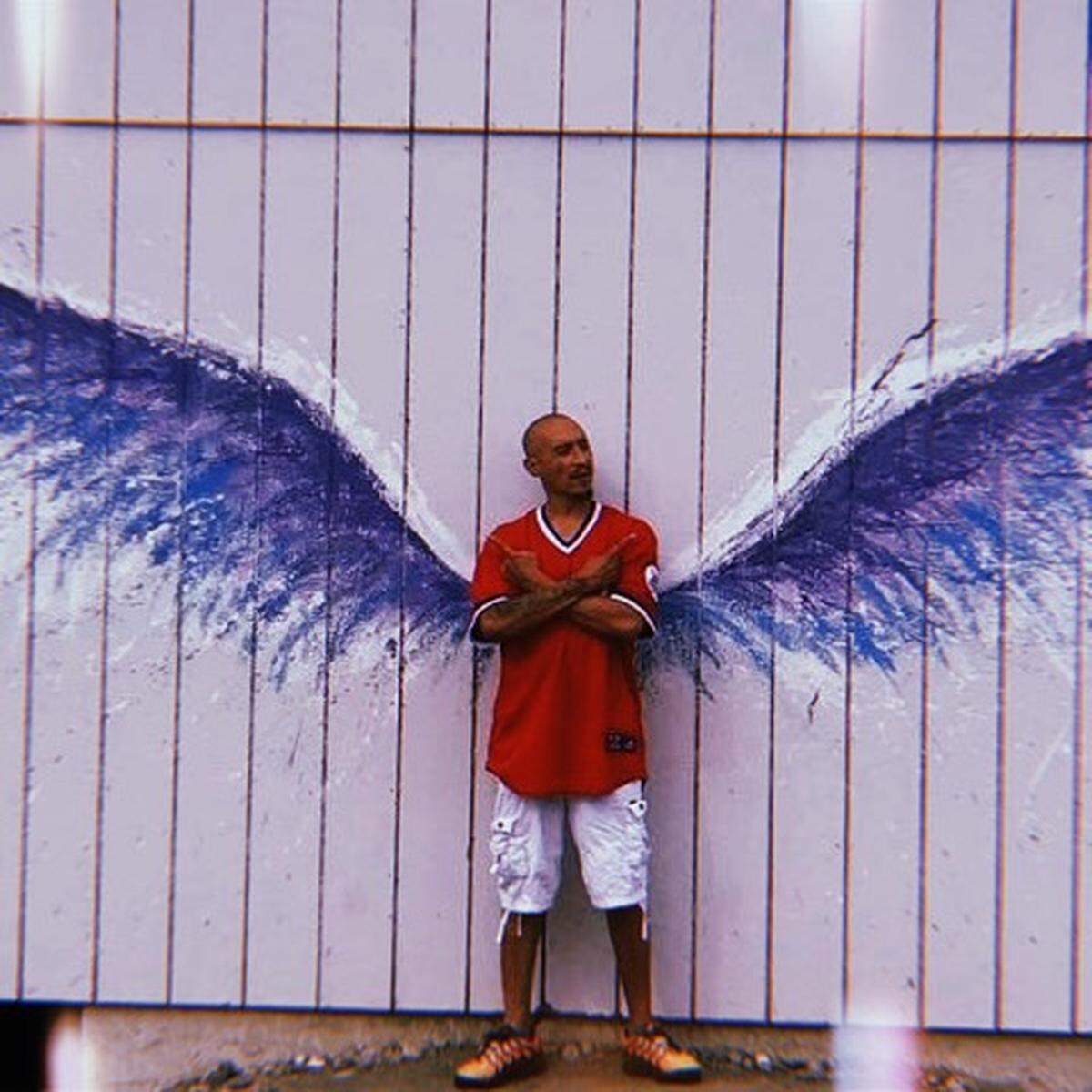 Gordon Whitaker, 45, stands in front of the “Angel Wings” mural.