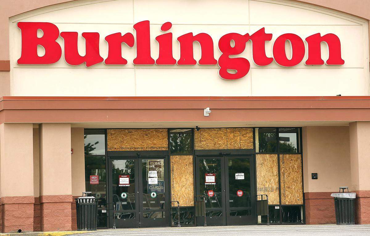 Windows damaged at the Burlington Coat Factory store on West Canal Drive are covered Monday with plywood after a crowd gathered to protest near Columbia Center mall late Sunday night turned unruly. One teen was arrested.