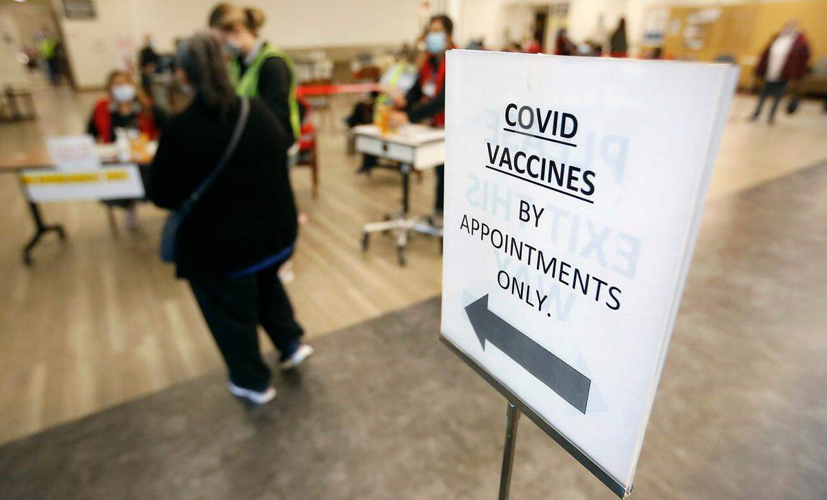People confirm their online registration with employees Friday morning for the COVID-19 community vaccination clinic held at the Kadlec Healthplex facility in Richland. There were 740 doses of the Moderna vaccination scheduled to be given to those meeting Phase 1A and Phase 1B Tier 1 eligibility, including people age 65 and older and those age 50 and older who live in a multi-generational household.