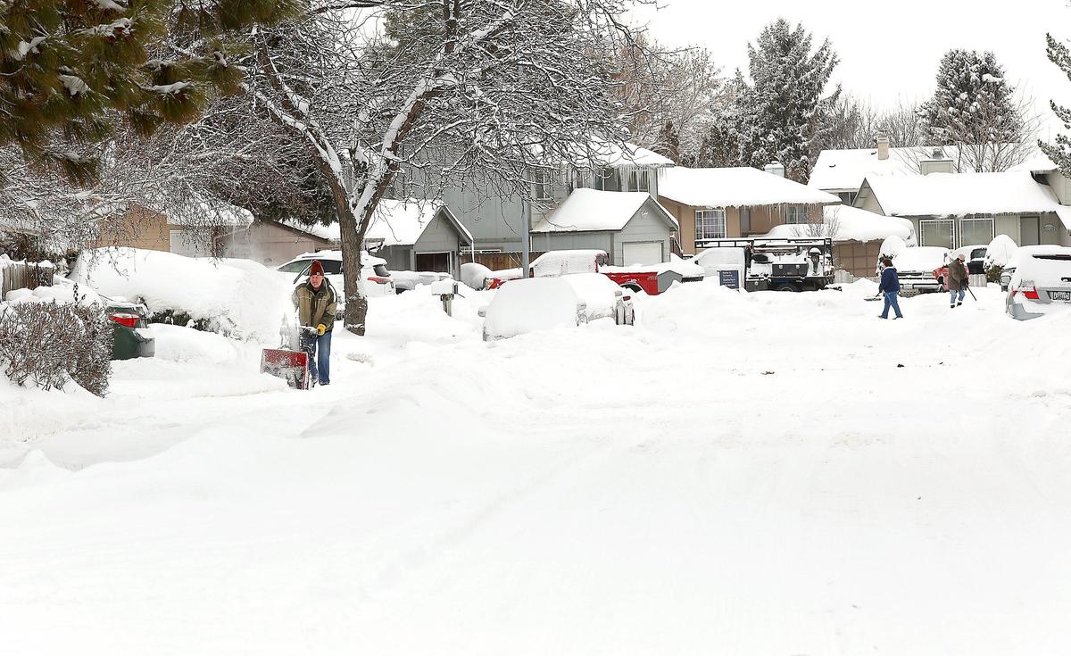 Neighbors in the 500 block of North Kansas Street in west Kennewick work Thursday morning with snowblowers and shovels clearing sidewalks and driveways following another winter storm that rolled across the Mid-Columbia.