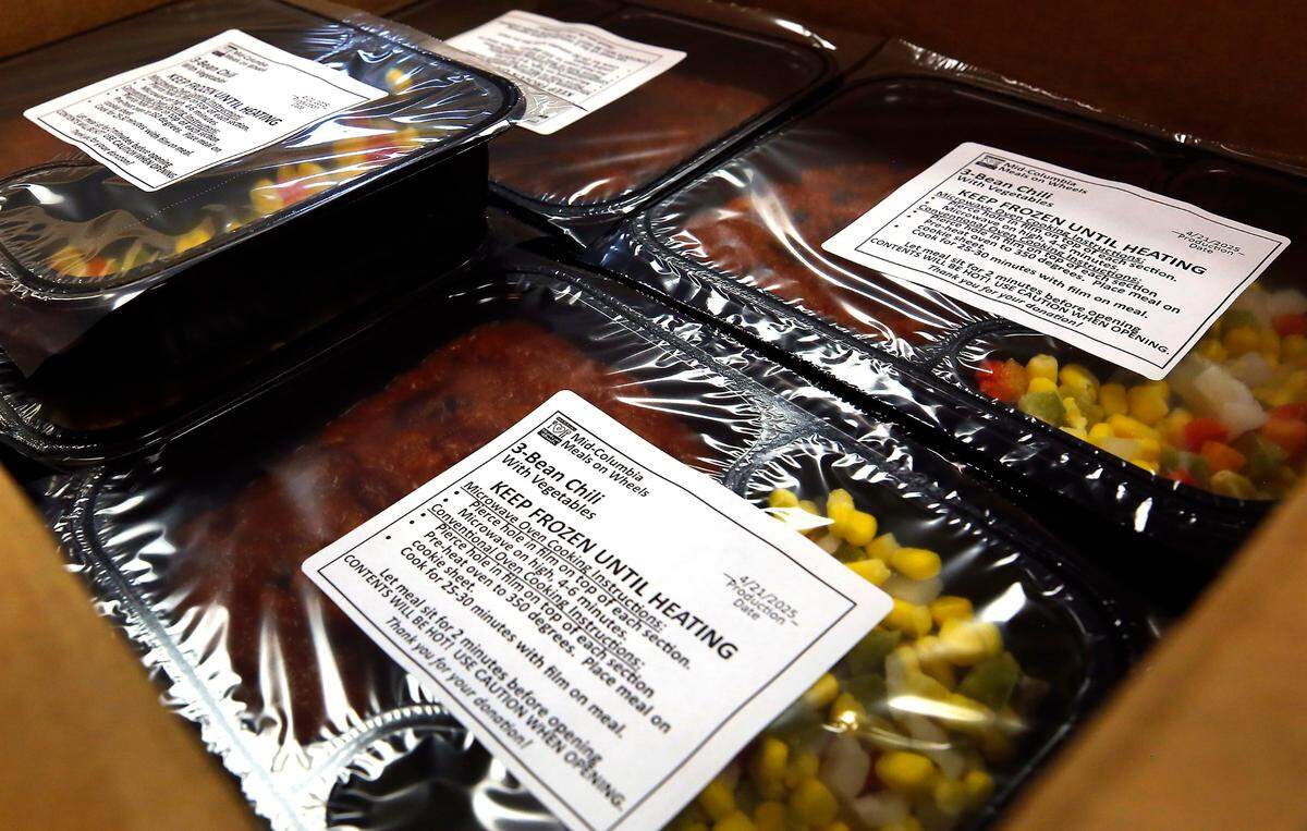 Meals packaged by volunteers are prepared for freezing in sealed and labeled trays at the Mid-Columbia Meals on Wheels kitchen in Richland.
