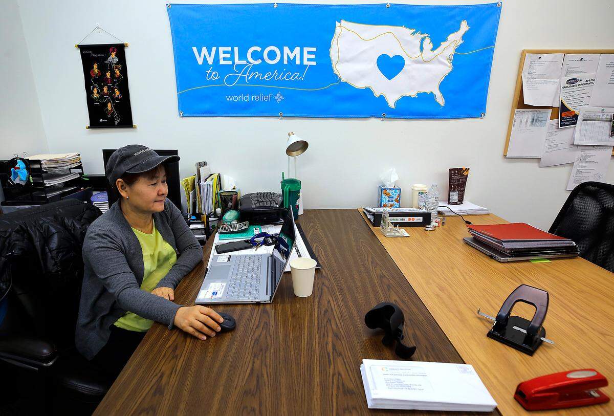 Myint Myint Sein, World Relief Tri-Cities resettlement coordinator, works at her desk in the organization’s Richland offices.