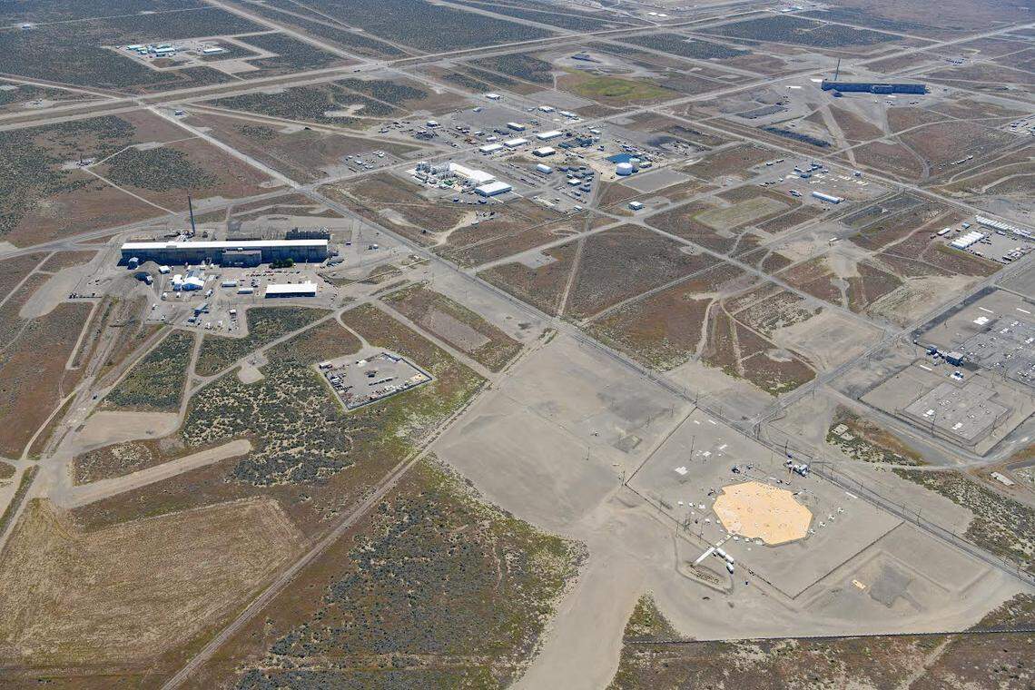 The T Tank Farm with 16 underground tanks, two of them suspected of actively leaking waste into the ground are shown from the air. A barrier has been built over part of the tank farm.