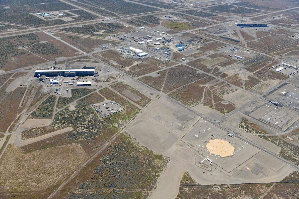 The T Tank Farm with 16 underground tanks, two of them suspected of actively leaking waste into the ground are shown from the air. A barrier has been built over part of the tank farm.