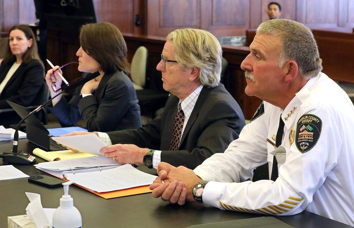 Franklin County Sheriff Jim Raymond sits with his attornery's as Walla Walla Superior Court Judge Brandon Johnson sets a deadline for turning over a fingerprint machine.