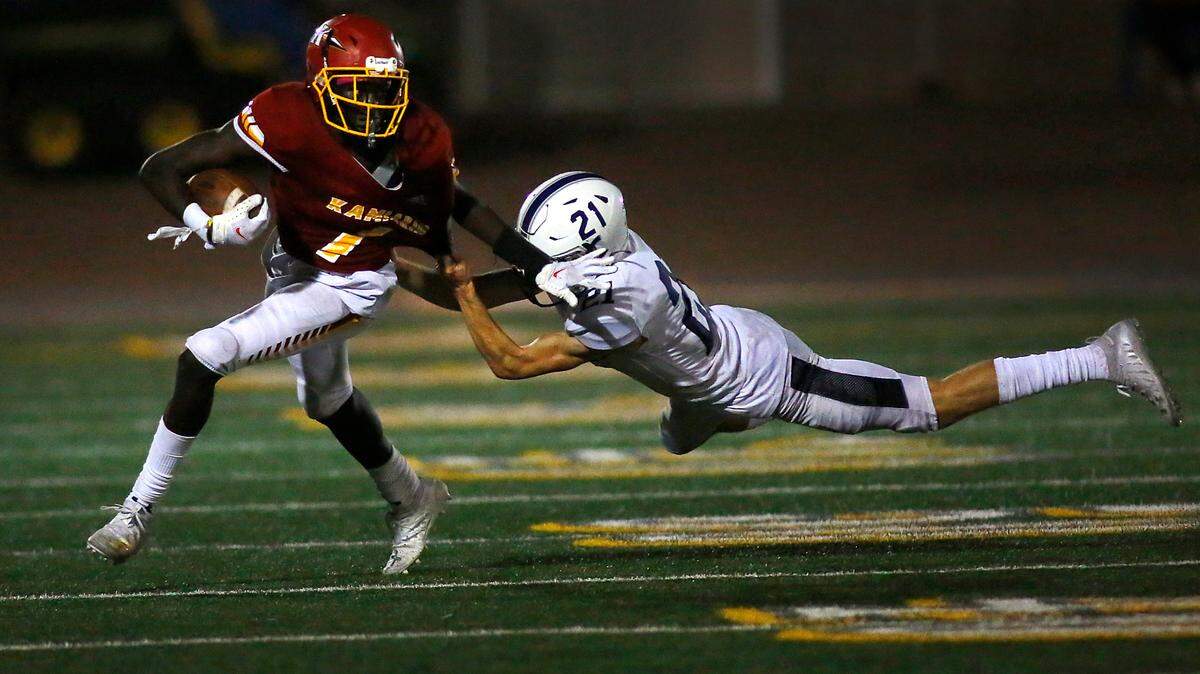Kamiakin’s Gabe Tahir shrugs off Chiawana defender Ian Mohl after catching a pass, then reversing the field and picking up a wall of blockers to run 42 yards for a touchdown during Thursday’s game at Lampson Stadium in Kennewick. The Braves won 46-24.