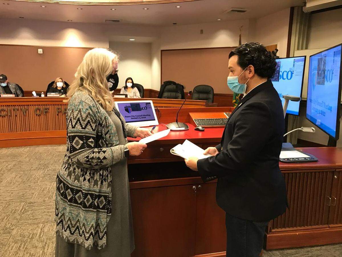 Pasco City Clerk Debby Barham, left, gives the oath of office Monday to new council member Joseph Campos.