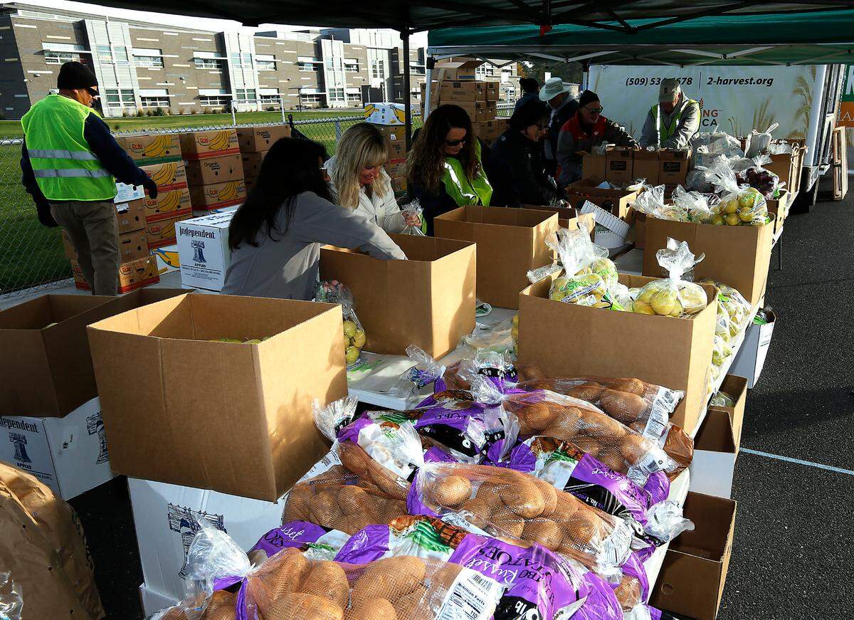 Volunteers from Hillspring Church in Richland prepare food bags at a 2nd Harvest Mobile Market food distibution.