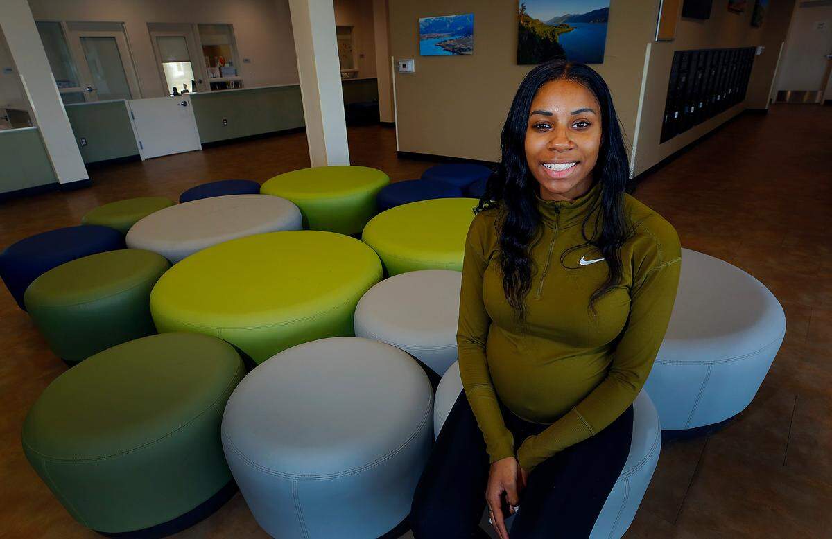 Allicia Chalmers, supportive housing coordinator, sits in the lobby of the Bishop Skystad Commons housing facility in Pasco.