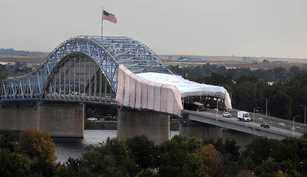 The tarps are being used prevent debris falling into the river or onto passing vehicles during the year-long, $33.5 million paint project.
