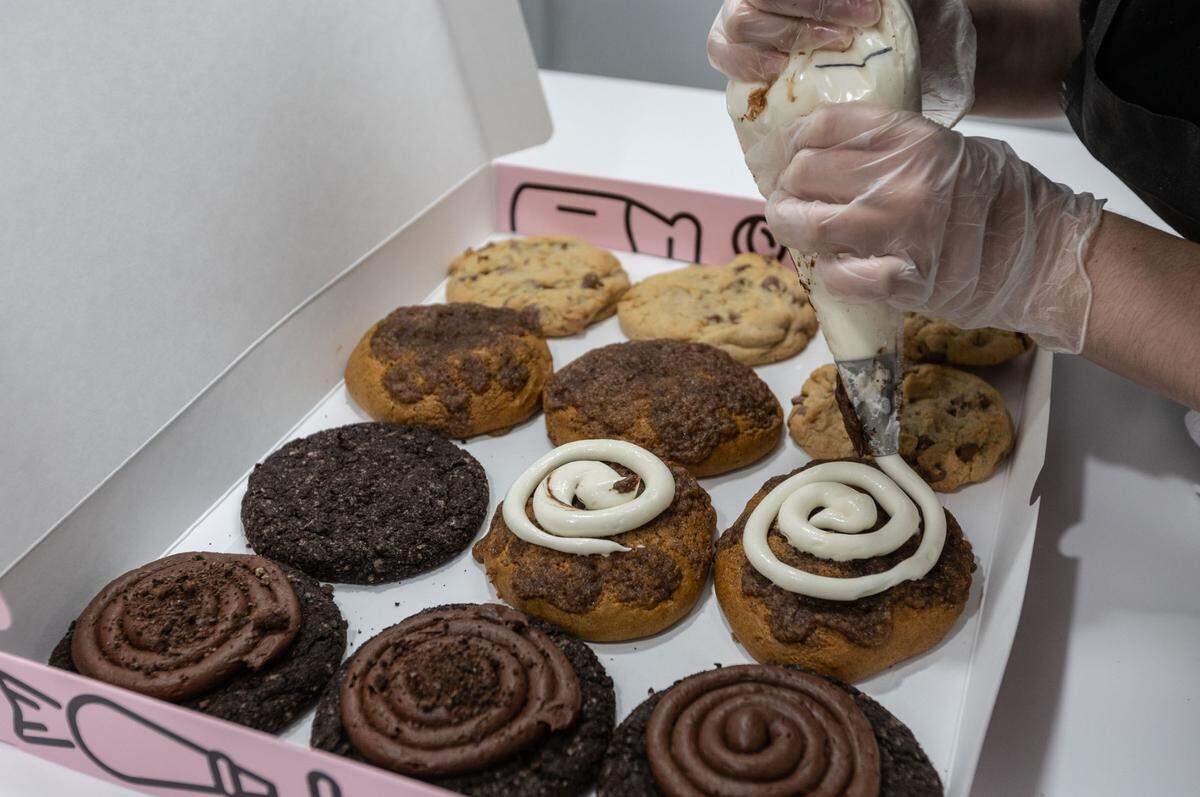 Workers place final icing and decorations on an order from Crumbl Cookies in Kennewick. The popular chain made its Tri-Cities debut in Richland in March and will soon have locations in all three cities, with a third set to open in Pasco off of Road 68.