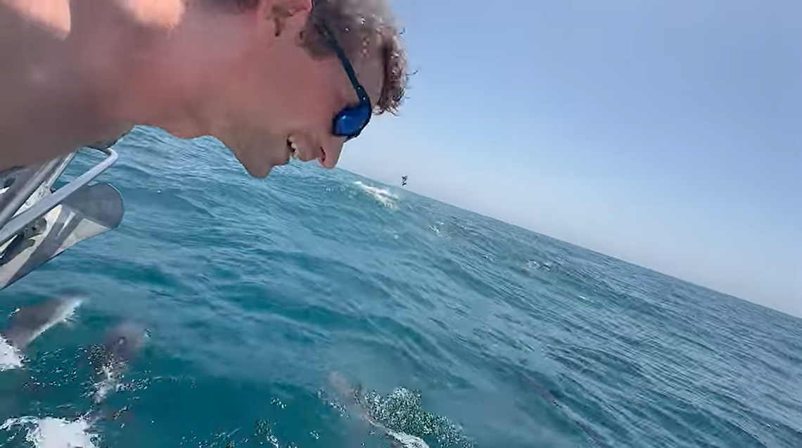Tri-Cities resident Kimmer O’Reilly greets dozens of dolphins during his solo Atlantic Ocean crossing. One can be seen jumping several feet in the air behind him.