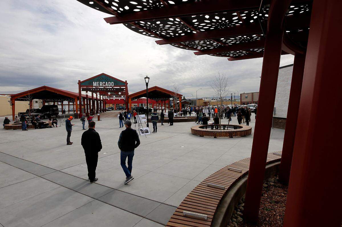 A crowd of about 200 people begins gathering for Friday afternoon’s ribbon cutting ceremony for the newly renovated Peanuts Park and Farmers Market in downtown Pasco.