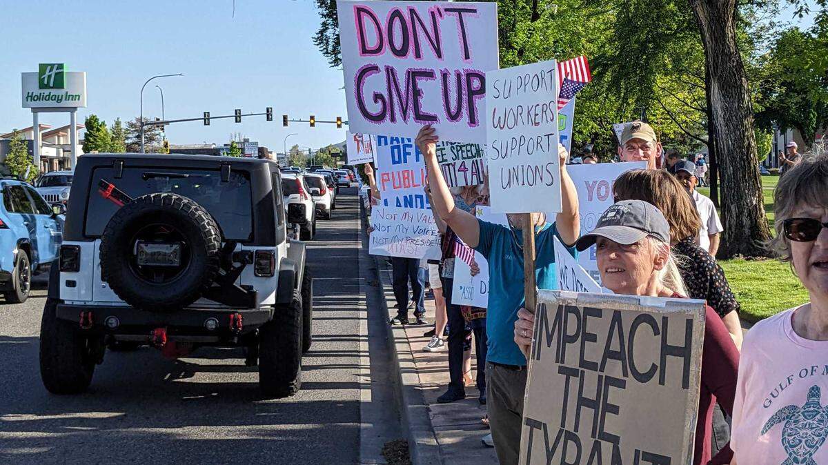 Hundreds of protesters waved signs and 5 p.m. commuters honked back in support of a May Day protest held at John Dam Plaza in Richland.
