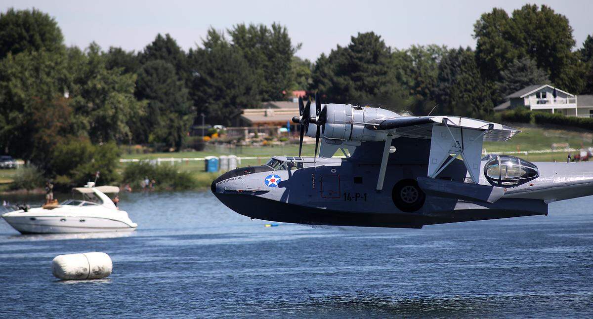 A 1943 PBY-5A Catalina airplane takes off from the Columbia River past marker buoys outlining the hydroplane race course during Friday’s Over-The River Air Show.