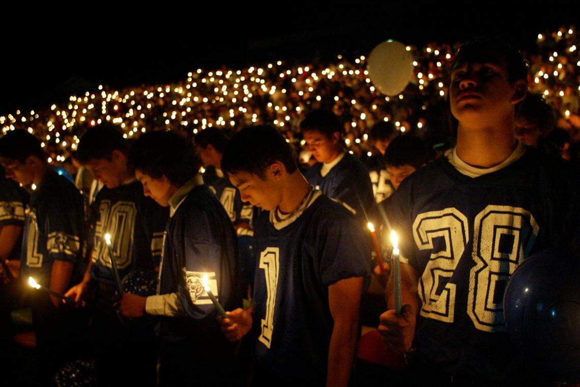 Kiona­-Benton High School football teammates hold candles during a memorial service in 2004 for slain coach Bob Mars. Hundreds gathered at the school’s football stadium to remember Mars, who also taught physical education