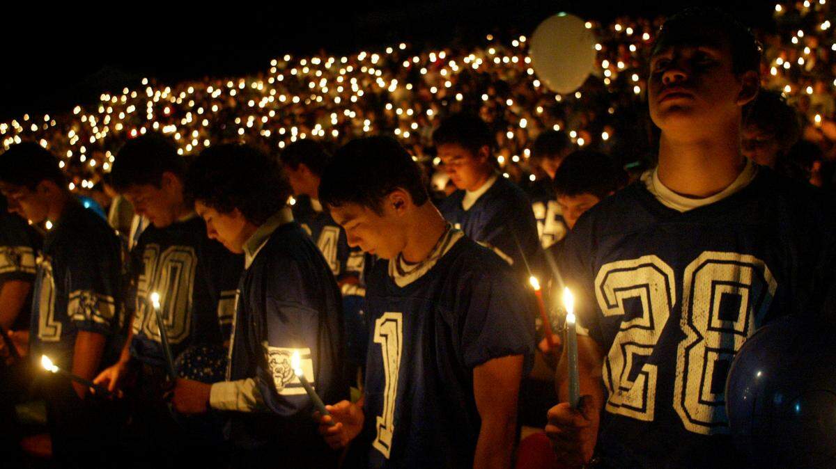 Kiona­-Benton High School football teammates hold candles during a memorial service in 2004 for slain coach Bob Mars. Hundreds gathered at the school’s football stadium to remember Mars, who also taught physical education