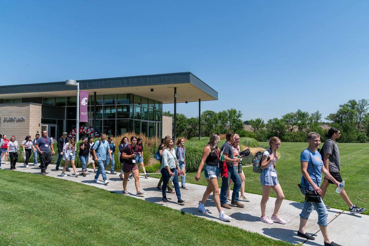 Washington State University Tri-Cities students and staff walk past the Student Union Building.