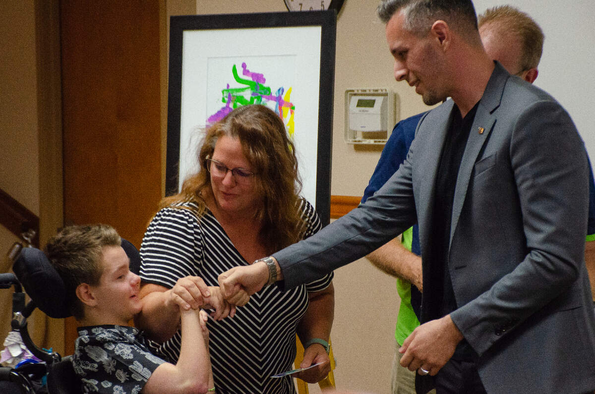 Gabe Scheel fist bumps Brian Moreno, past chair of the Washington State Commission on Hispanic Affairs, who presented the 13-year-old with a Shining Light Award and letter of recognition from Gov. Jay Inslee.