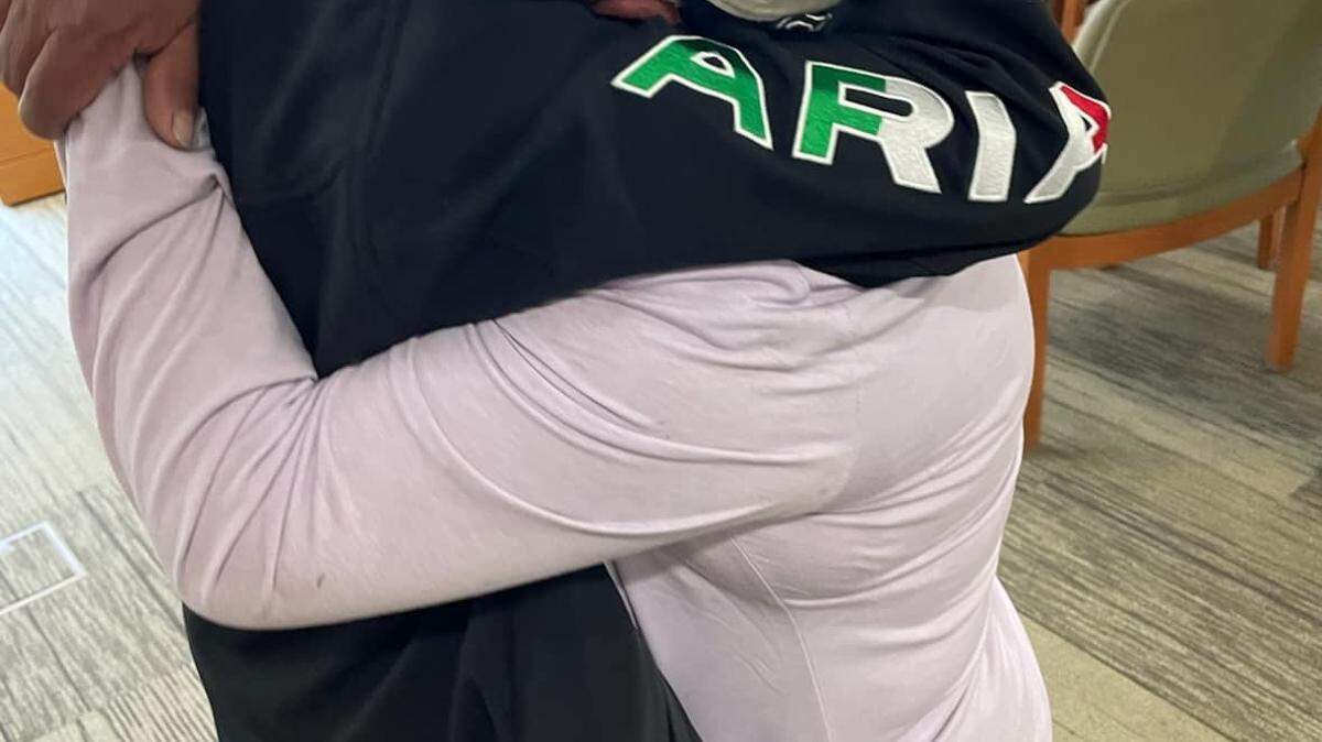 A mother and daughter hug after learning the girl was safe following a virtual kidnap scam.