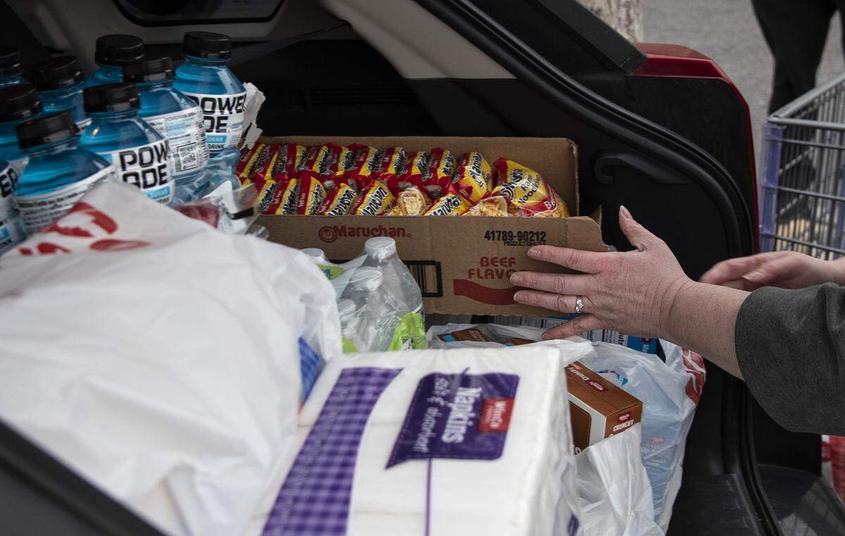 Fallon Mayer, 37, loads bulk items into her car after shopping at WinCo in Kennewick in preparation for the possible escalation of the coronavirus outbreak. Mayer works in the restaurant industry and has already seen a decline in customers. “We’re on a hiring freeze so we can’t hire any more people,” she said. “[We’re told to] just be prepared to be sent home if it’s super slow.”