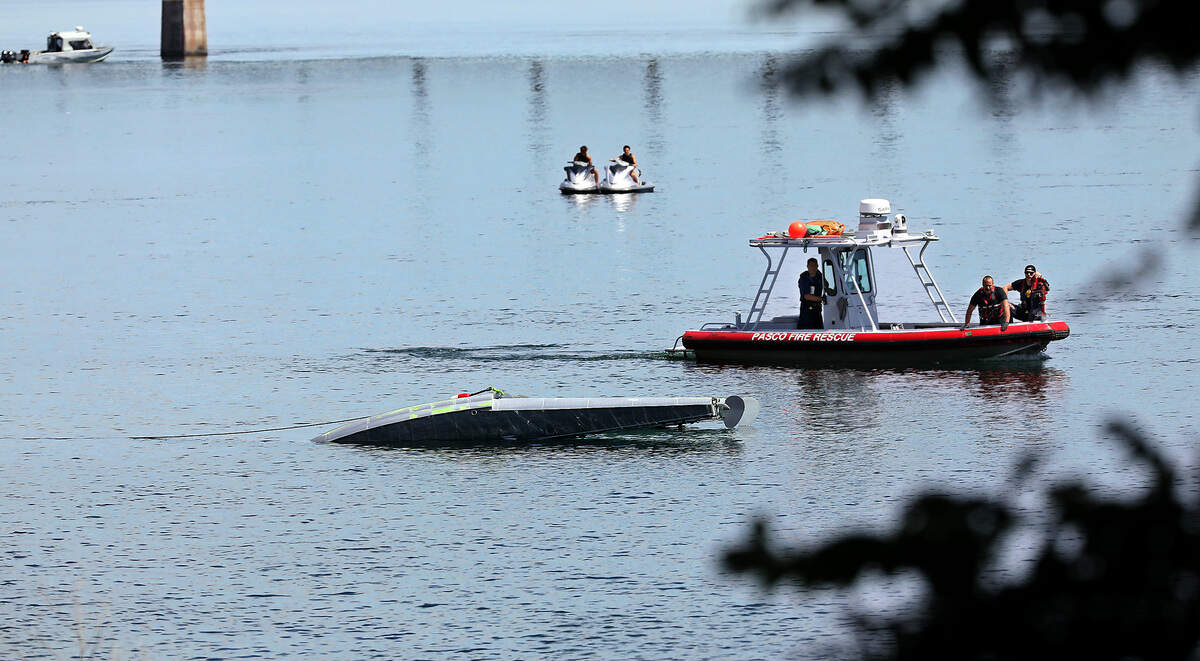 The Pasco Fire rescue boat moves into position next to the submerged floatplane that crashed into Columbia River, as a crane prepared to lift it from the water just below the cable bridge. Two men onboard were killed.