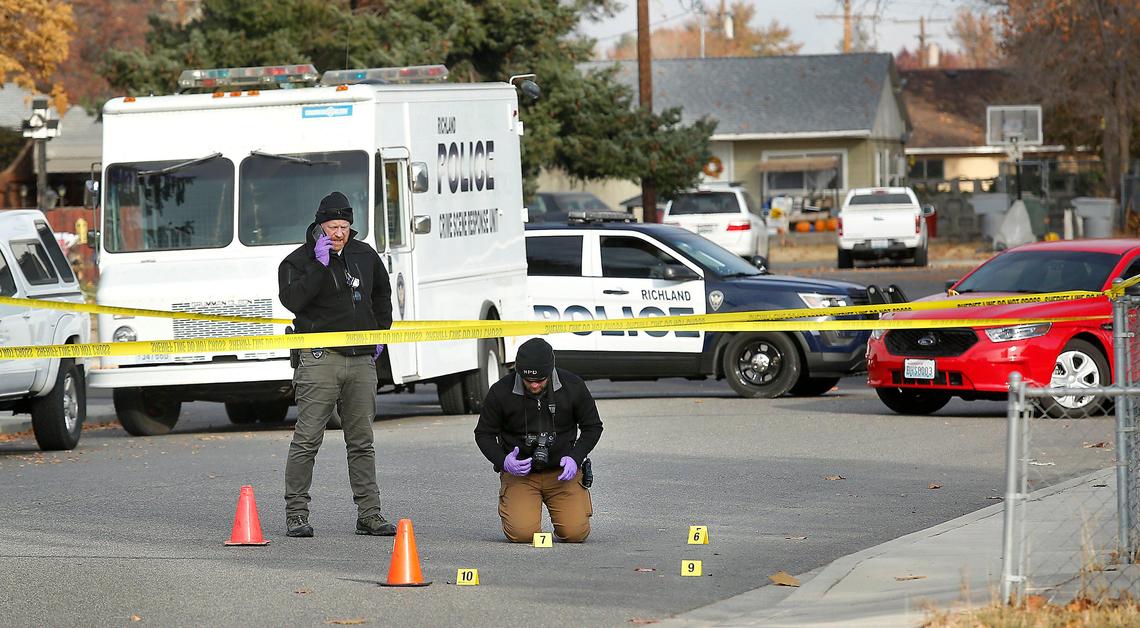 Richland police investigators photograph evidence Monday left in the 1200 block of Winslow Avenue from a fight and shooting that sent two men to the hospital, one with several bullet wounds. Watch a video at: tricityherald.com/video.