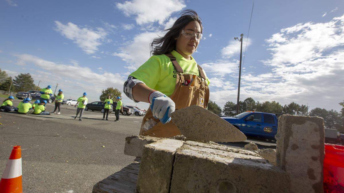 Chiawana High School senior Samantha Vazquez lays mud on a brick during the 14th annual Construction Career Day at the Benton County Fairgrounds in Kennewick. Vazquez is one of 500 Mid-Columbia students who tried hands-on construction techniques Tuesday. The event tries to teach students about opportunities in the construction industry after high school.