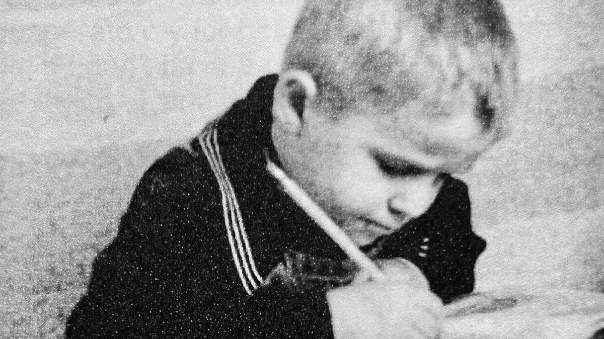 Andrew Hrebeniuk holds a pencil for the first time in a refugee holding area after being rescued from a Parshen, German Nazi labor camp at the end of WWII.