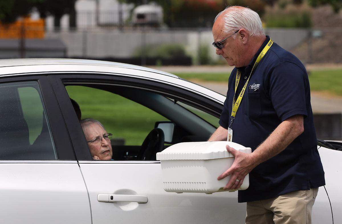 Benton County Coroner Bill Leach pauses Thursday afternoon for Judi Nelson of West Richland to see and touch the small casket with the remains of Baby Doe during a reinterment ceremony at Richland’s Resthaven Cemetery.