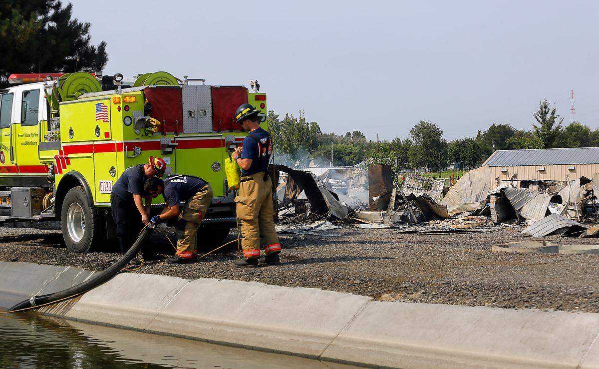 Benton County firefighters finish filling the tank on their fire truck from an irrigation canal adjacent to East Bryson Brown Road near S. 2179 PrSE to quench smoldering hot spots of a building destroyed by fire during a violent and fiery rampage that began in Finley and ended in West Richland. The 43-year-old suspect died in his burning pickup truck during a shootout with police on Van Giesen Street.