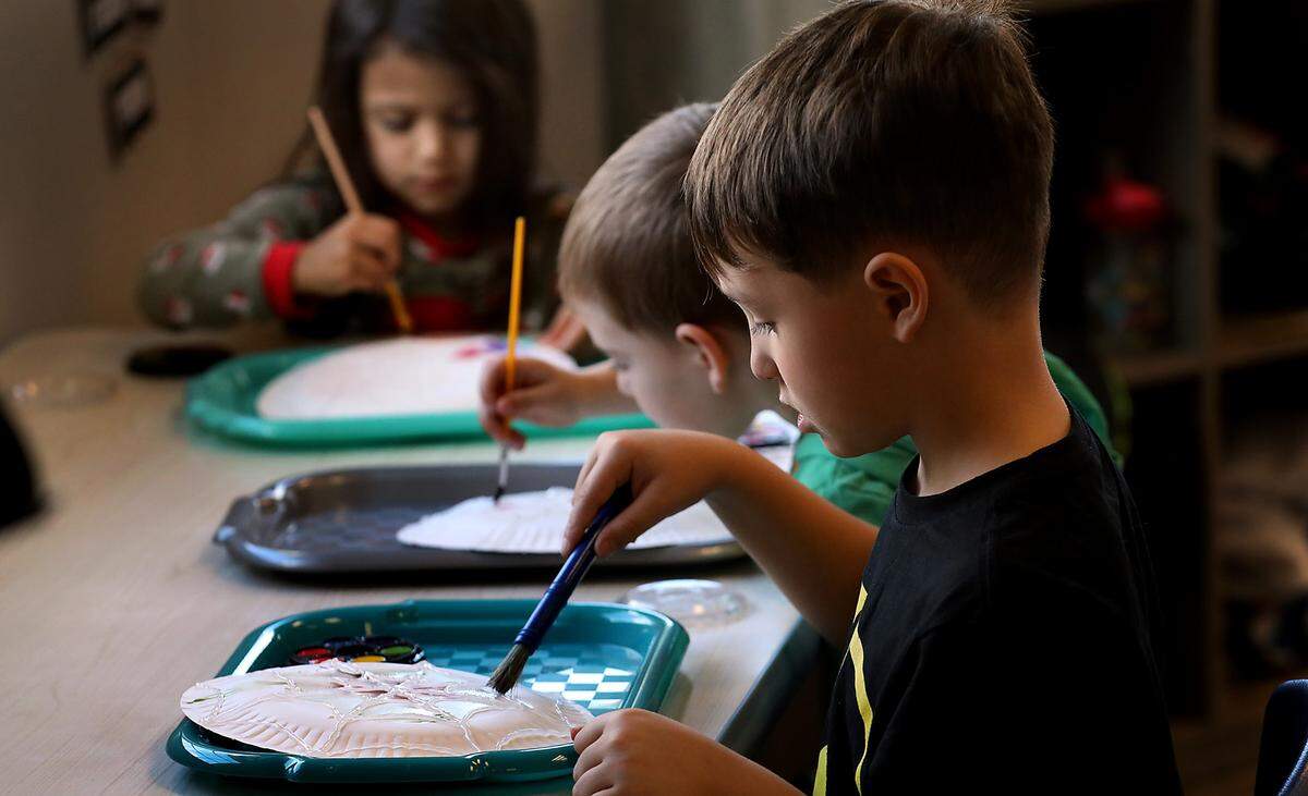 Damien Sullivan, a full-time preschool student at Level Up Learning, works near two classmates during their art and crafts session at the Kennewick childcare facility.