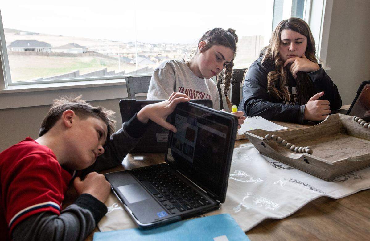 Olivia Galbraith, right, a senior at Kamiakin High, her sister Danika, a sophomore at Southridge High, and brother Bryce, a fourth-grader, work on their homework at home. Distance learning has presented challenges, especially Olivia who helps teach her little brother while her parents are at work.