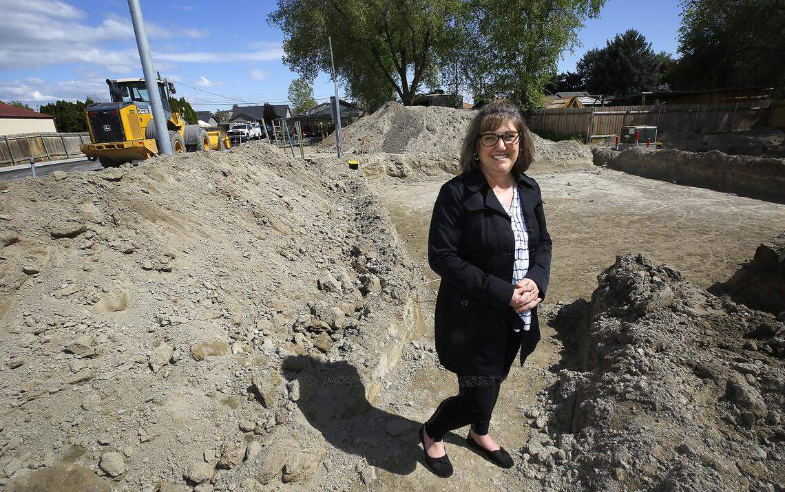 Lisa Godwin of Elijah Family Homes stands in the excavated site for one of the new building being built for their new cottage community.