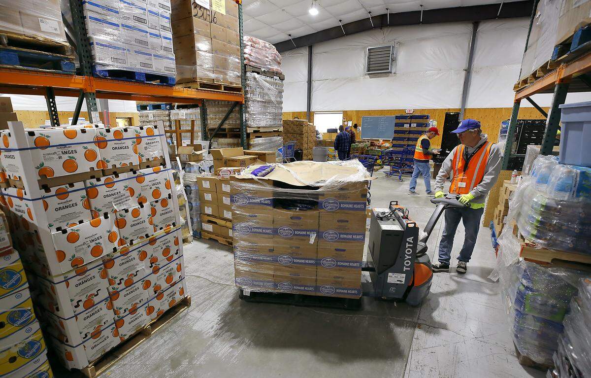 Volunteer Jim Mahoney moves a pallet of lettuce during a recent food distribution day at the St. Vincent de Paul Food Bank & Community Services campus in Pasco.