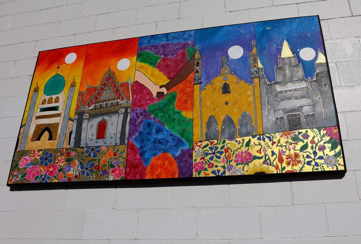 A mural by Aleah Mahaffey depicts a series of four temples, embellished with detailed flowers and reflective gold paint.&nbsp;