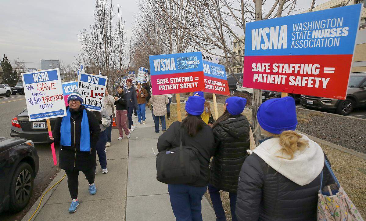 Dozens of nurses with the Washington State Nurses Association hold an informational picket Monday in Richland.
