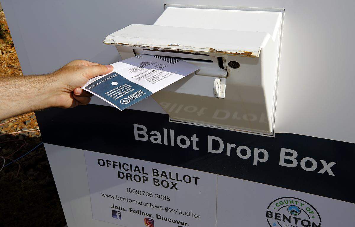 A Benton County voter drops off a ballot for the November 2025 general election at a downtown Kennewick drop box.