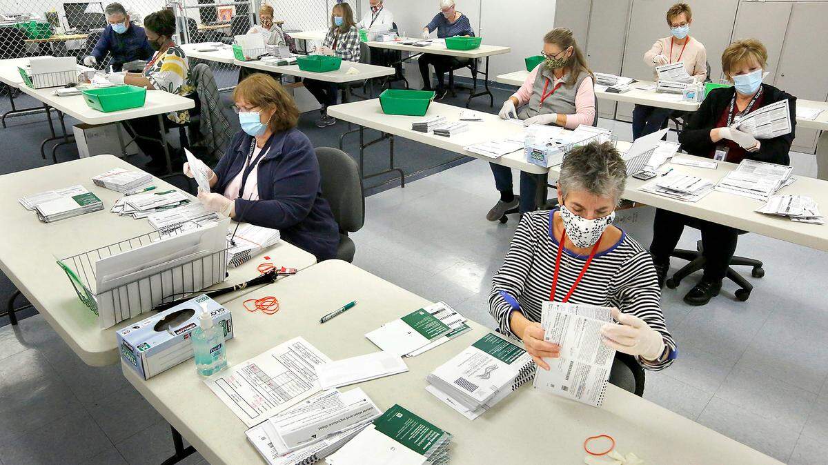 Teams of temporary election workers open ballot envelopes and visually inspect them for stray marks during a recent election in Pasco.