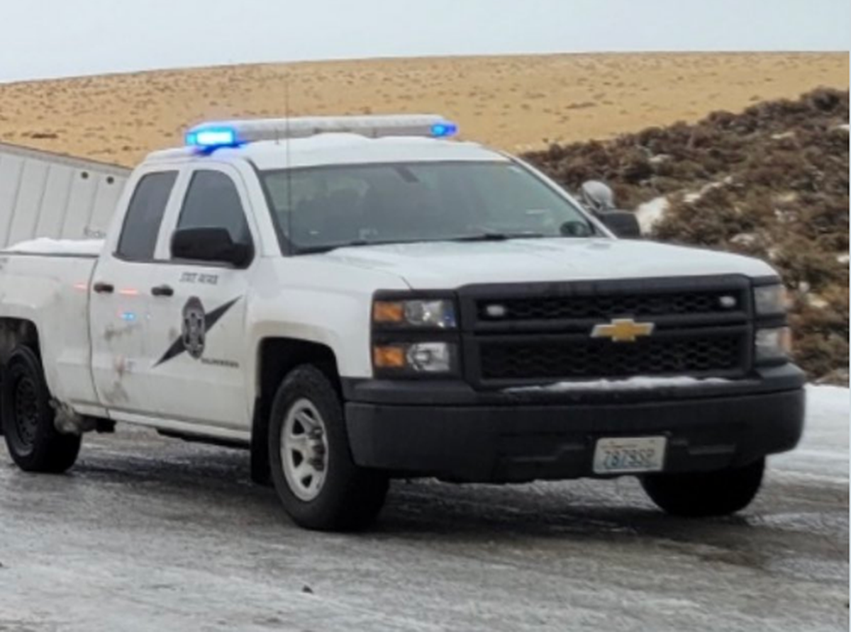 A Washington State Patrol pickup stops on snow-packed Interstate 82 by a semi rollover that killed one person Saturday morning just south of Kennewick.