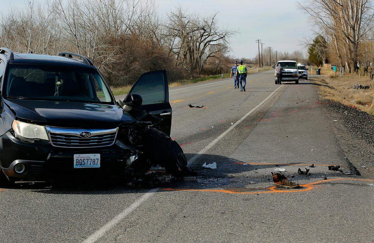 Troopers from the Washington State Patrol investigate the scene of Monday’s fatal collision between a car and motorcycle on Highway 397.
