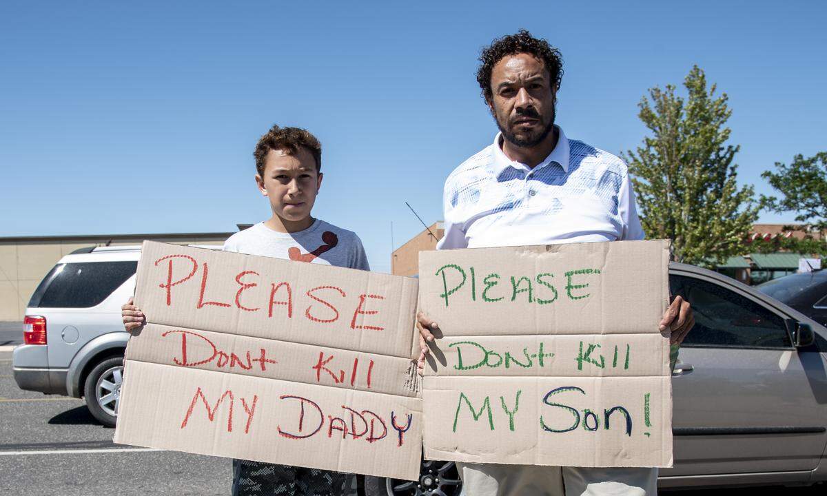 From right to left, Larry, 48, and Jordan Riggs, 10, carried homemade signs during a peaceful protest against police brutality and violence against black people in Pasco on Sunday. “We wanted to create something that could be related to but not speak hate,” Larry said of the signs.