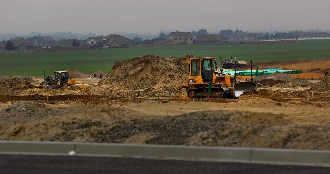 Earth moving equipment and construction workers prepare the ground for a new residential subdivision off Burns Road west of Broadmoor Boulevard in west Pasco.