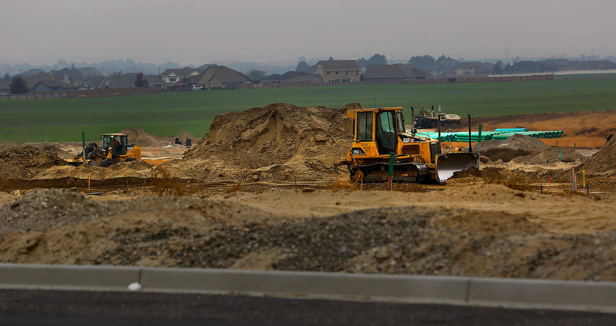 Earth moving equipment and construction workers prepare the ground for a new residential subdivision off Burns Road west of Broadmoor Boulevard in west Pasco.