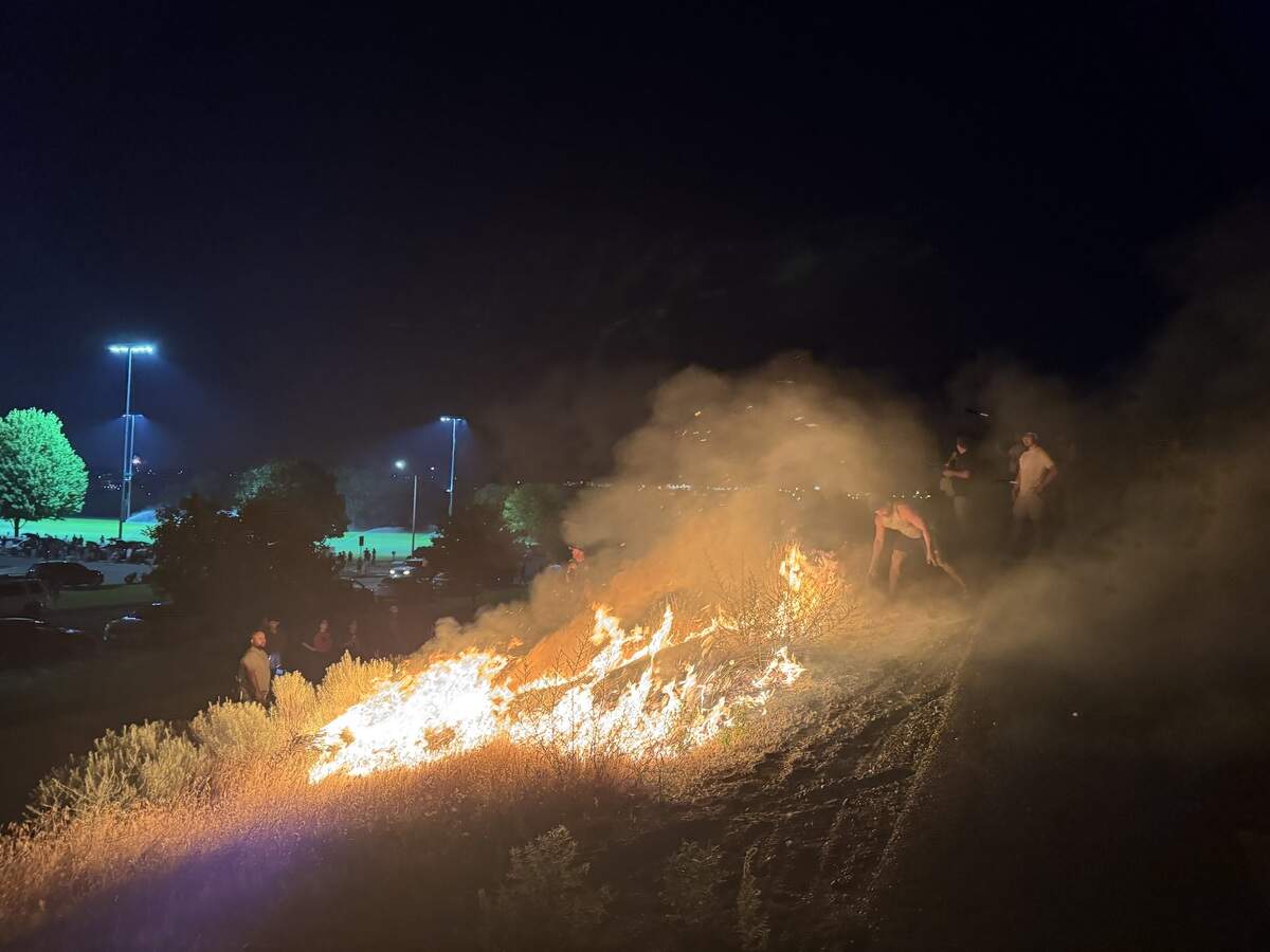 Police and bystanders reacted to a grass fire started by fireworks on the embankment of the Interstate 182 bridge at Columbia Point Marina Park in Richland on July 4.