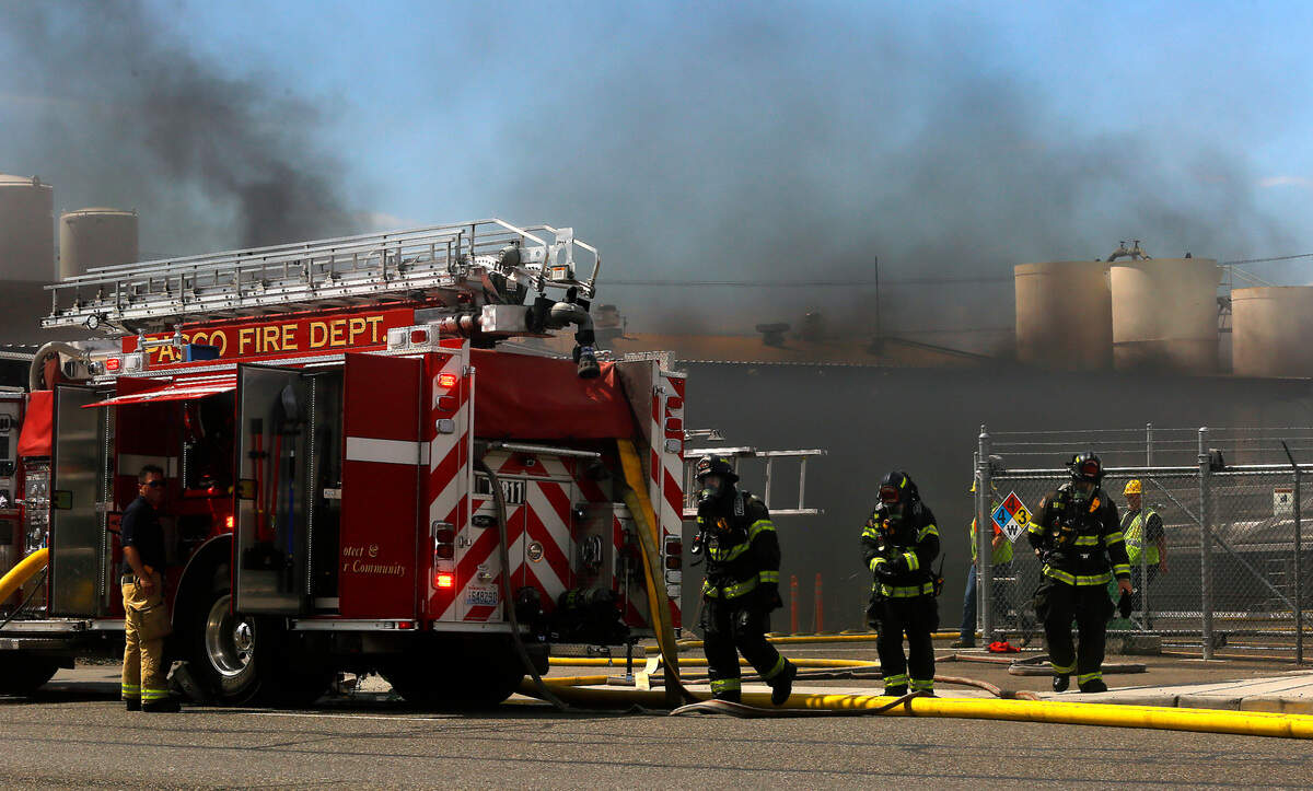 Firefighters from around the Tri-Cities area methodically work Tuesday to extinguish a fire in the acetylene manufacturing room at the Oxarc Inc. business on the corner of A Street and Oregon Avenue in Pasco. No injuries were reported.