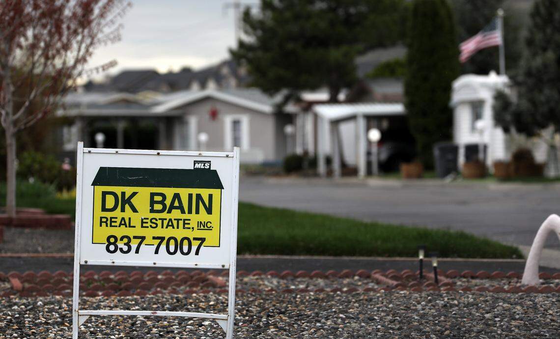 A real estate for sale sign in the front yard of a manufactured home in a west Kennewick mobile home park.