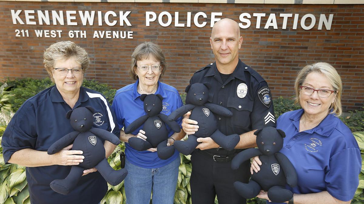 Kennewick Police volunteers Debbie Espinoza, from left, Jeanne Murphy and Annette Kuhl are joined by Sgt. Aaron Clem holding stuffed bears outside the Kennewick Police Station on West Sixth Avenue. Police volunteers recently started putting bears together from old uniforms to go to children in pediatric care.