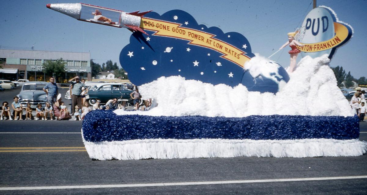 A colorful float for the Benton-Franklin PUD drives past community members lining the sidewalk in front of the Uptown Shopping Center in Richland.