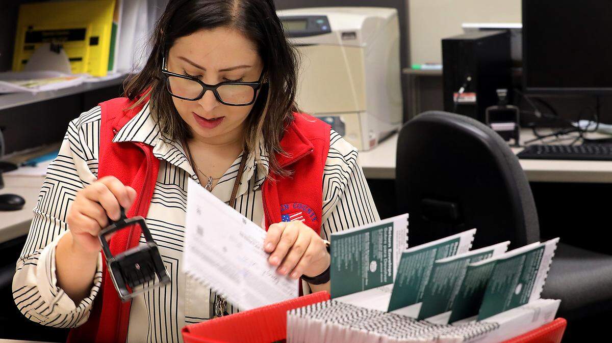 Elections assistant Aracely Medina count and batch ballots from the drop box at the Franklin County Courthouse Tuesday morning at the Franklin County Elections Center facility.